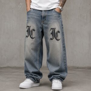 Light blue oversized baggy jeans featuring bold black embroidered JC logos on both thighs, showcasing a premium streetwear design by Jatt Clothing.